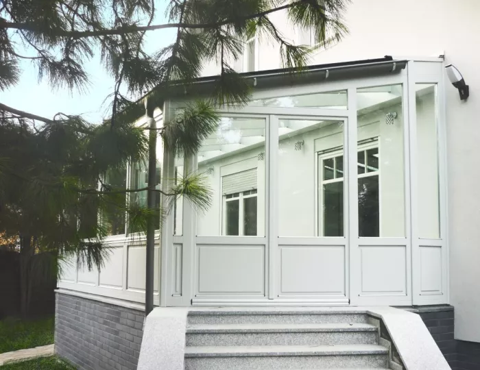 Ogród zimowy z drewnianymi białymi oknami