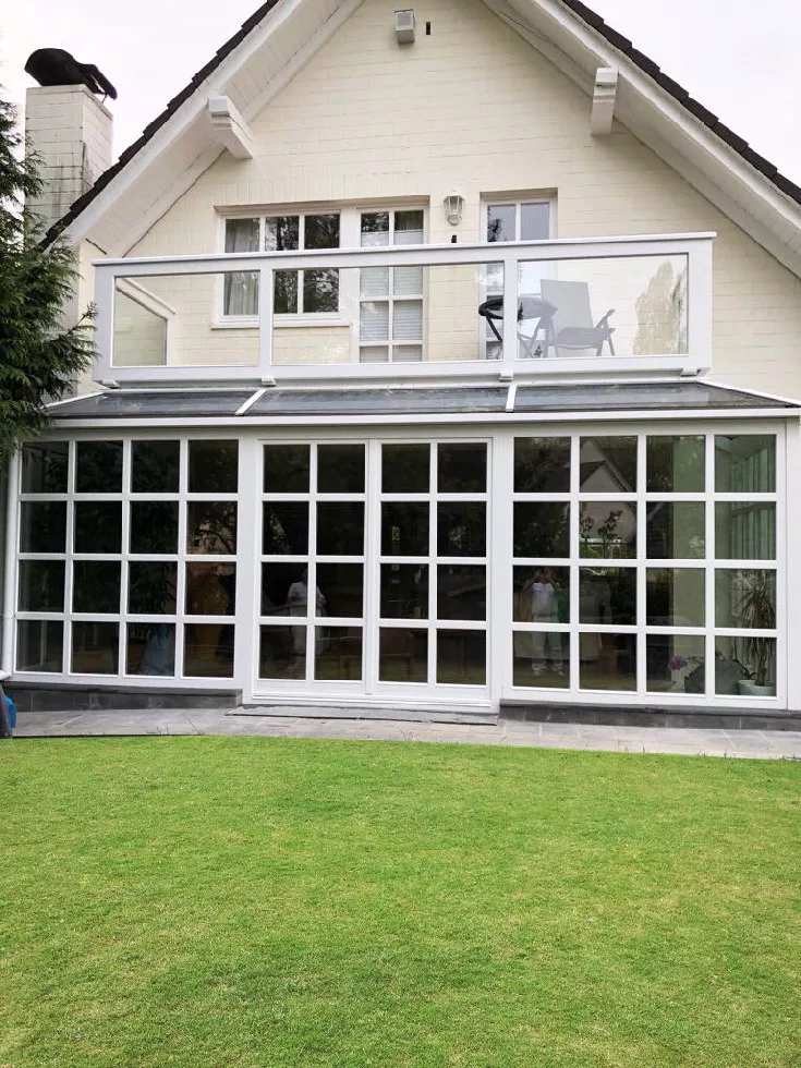 Ogród zimowy z drewnianymi białymi oknami